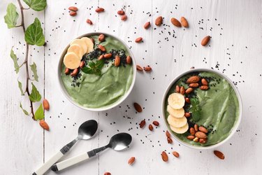 Bowls with tasty spirulina smoothie on white table