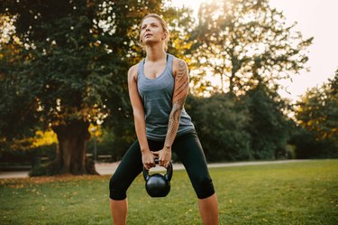 woman exercising with kettlebell for full-body strength workout