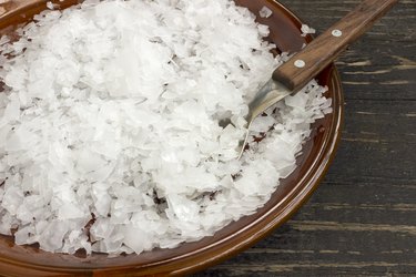 Magnesium chloride flakes in a saucer