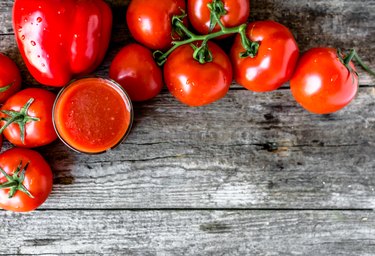 Glass of tomato juice on wooden table, flat lay from above