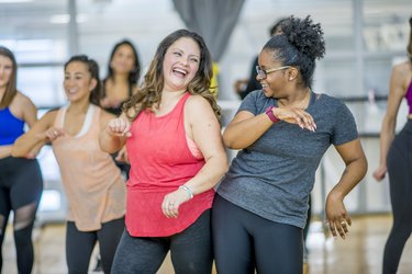 Two women dancing together in a group class at a gym