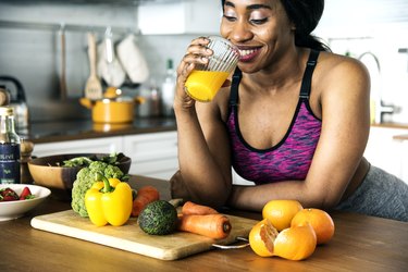 An active woman drinks a homemade electrolyte drink in her kitchen