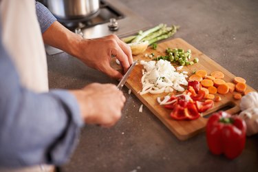 person cutting up fresh vegetables, as a natural remedy for enlarged prostate