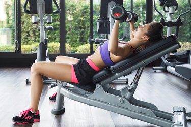 Woman performing incline bench press.