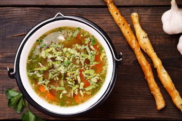 Homemade chicken vegetable soup on wooden table