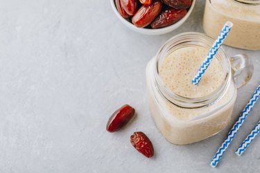 Banana and date fruit smoothie or milkshake in glass mason jar