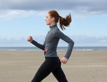 Young woman running by the beach
