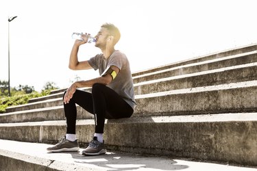 Athlete resting and re-hydrating with water