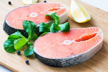 Fresh raw salmon steaks on wooden board