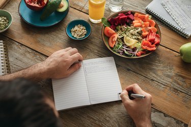 A man on the CICO diet writing in a food journal