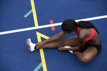 Runner stretching on track