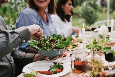 Friends enjoying a dinner together in greenhouse harvest party