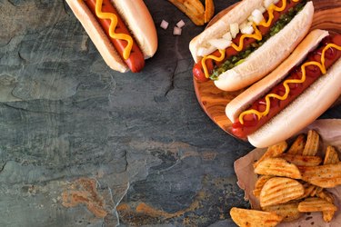 Hot dog corner border, overhead view on a dark stone background