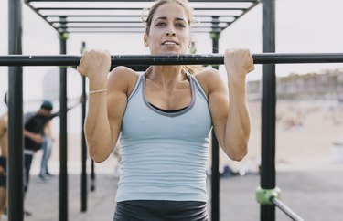 Woman Doing Pull-Ups on Monkey Bars for Fitness