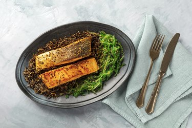 Grilled salmon with sesame seeds, wakame seaweed and wild rice, overhead shot