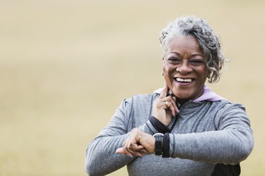 Senior woman exercising, taking pulse