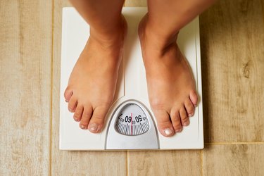 Female bare feet on weight scale in a bathroom