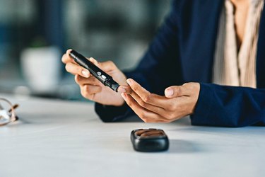 Woman with diabetes checking blood sugar levels to monitor for hyperglycemia over 400