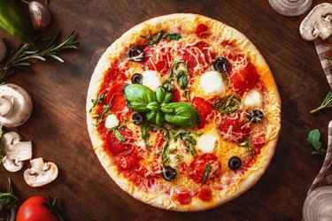 Hot pizza with Pepperoni  with vegetables and fresh ingredients on rustic wooden table. Pizza menu. View from above.