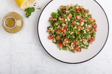 Tabbouleh salad with bulgur, fresh herbs, vegetables and  salad  dressing