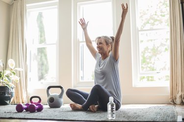 Smiling woman at home using kettlebells for weight loss