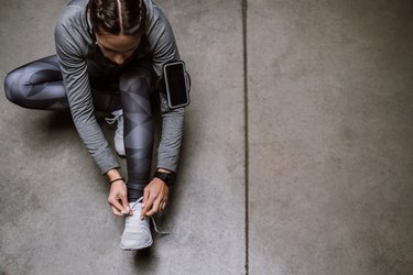 overhead shot of person getting ready to exercise after a tooth extraction tying shoe