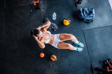 Beautiful Brazilian woman exercising abs on cross training