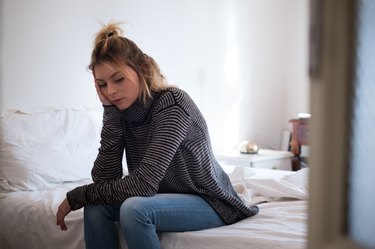 Sick woman sitting on the bed