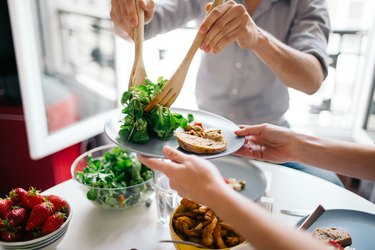 朋友在餐桌上享受沙拉、和维生素K作为食品的一个例子