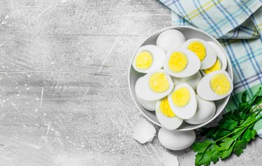 Boiled eggs in a bowl with parsley.