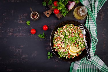 Tabbouleh salad. Traditional middle eastern or arab dish. Levantine vegetarian salad with parsley, mint, bulgur, tomato. Top view