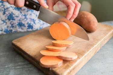 Carbohydrates Close Up Of Woman Preparing Sweet Potato On Chopping Board