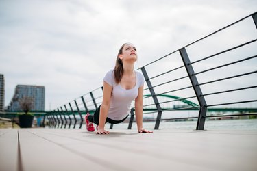 女运动员在户外做伸展运动。