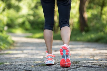 young fitness woman hiker legs at forest trail