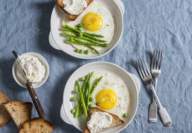 Delicious breakfast - fried egg, asparagus and cheese sandwich. On a blue background, top view