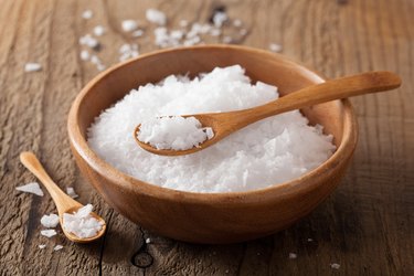 Sea salt and spoons in wooden bowl