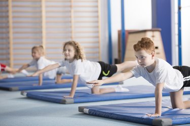 Kids exercising balancing yoga pose