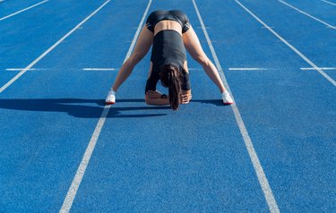 Sportswoman stretching before run on stadium