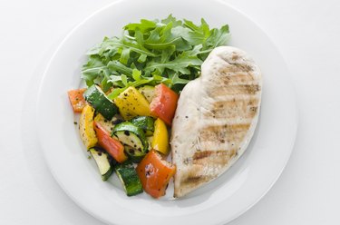 Chicken and roasted veg with lettuce on white plate