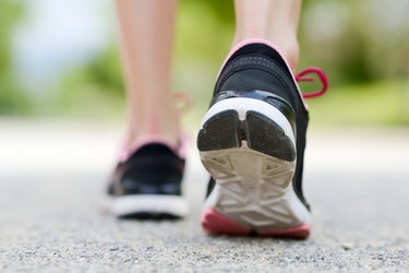 Low Section Of Woman Wearing Shoes Walking On Road