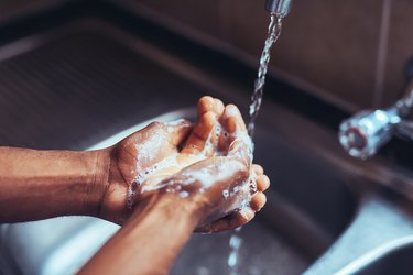 handwashing concept close up of soapy hands and running water