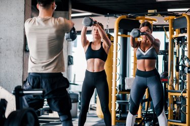 Trainer exercising with his clients at the gym.