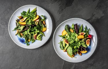 Fresh salad plates on black background