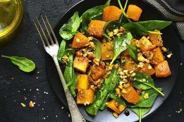 Steamed pumpkin salad with spinach and walnut .Top view.