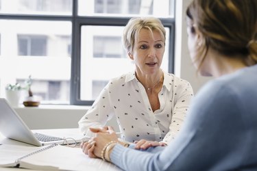 Businesswoman consoling colleague in office