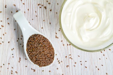 Psyllium fiber in a spoon with plain yogurt in bowl