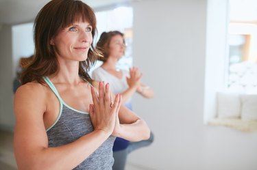 Female trainer with student doing Vrikshasana