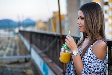 Beautiful woman drinking smoothie on roof