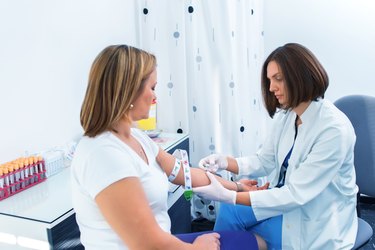 Woman and doctor preparing for cholesterol blood test