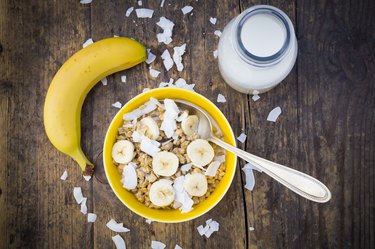 Bowl of granola, banana slices and coconut flakes